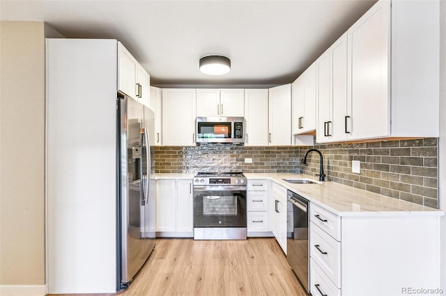 725 S Alton Way Unit 9C, Denver, CO 80247 - kitchen featuring stainless steel appliances, light wood-type flooring, light stone countertops, and white cabinets