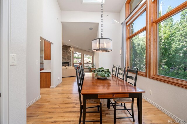 dining area featuring light hardwood / wood-style floors, an inviting chandelier, and a large fireplace