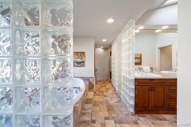 bathroom with vanity and a bath