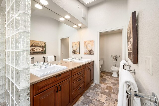 bathroom featuring vanity, toilet, and a bidet