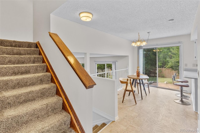 8441 S Timberwood St, Highlands Ranch, CO 80126 - stairs featuring a chandelier, a textured ceiling, and plenty of natural light