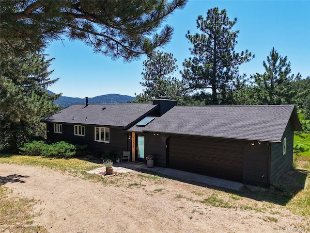 29858 Gigi Dr, Evergreen, CO 80439 - view of front of house with driveway, an attached garage, roof with shingles, and a mountain view