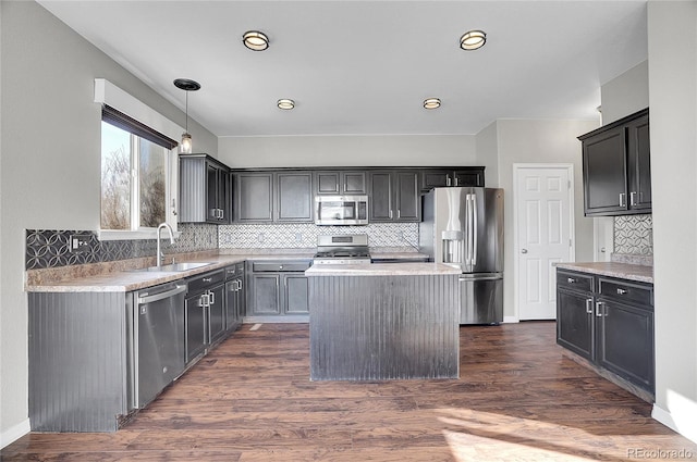 kitchen featuring sink, a center island, hanging light fixtures, stainless steel appliances, and dark hardwood / wood-style flooring