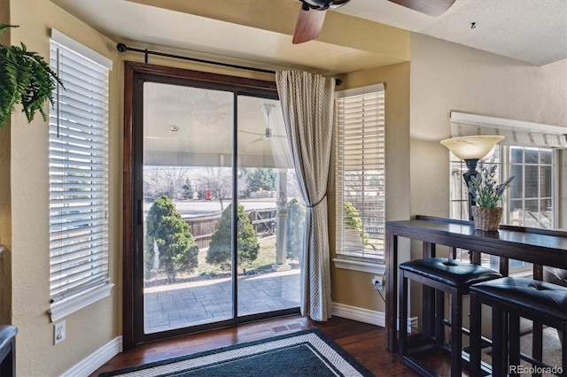 dining room with visible vents, ceiling fan, dark wood-type flooring, and baseboards