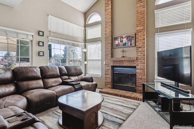 carpeted living area featuring a brick fireplace and high vaulted ceiling