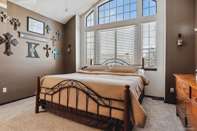 bedroom with light colored carpet, baseboards, and vaulted ceiling