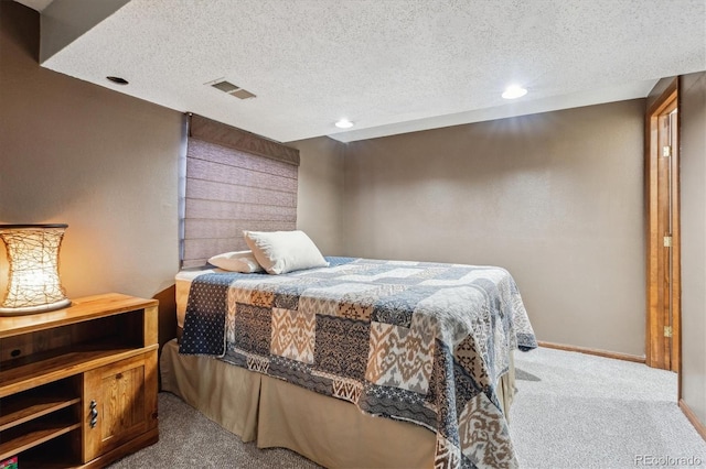 carpeted bedroom with visible vents, baseboards, and a textured ceiling