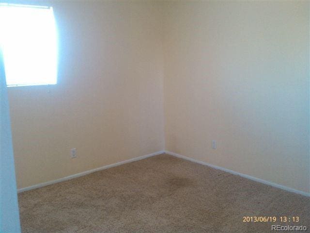 unfurnished room featuring carpet flooring and baseboards
