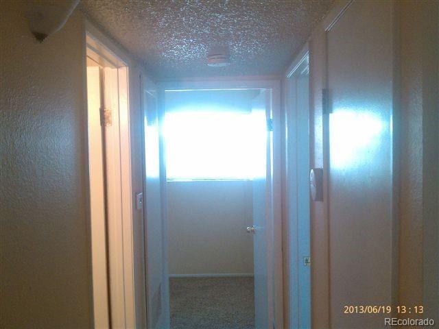 hallway with a textured ceiling