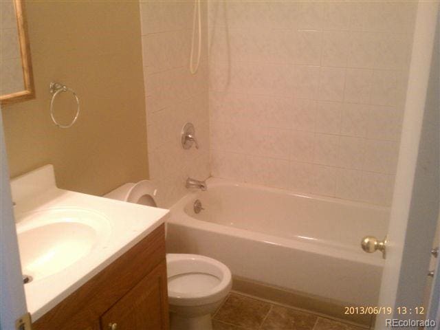 full bath featuring toilet, washtub / shower combination, tile patterned floors, and vanity