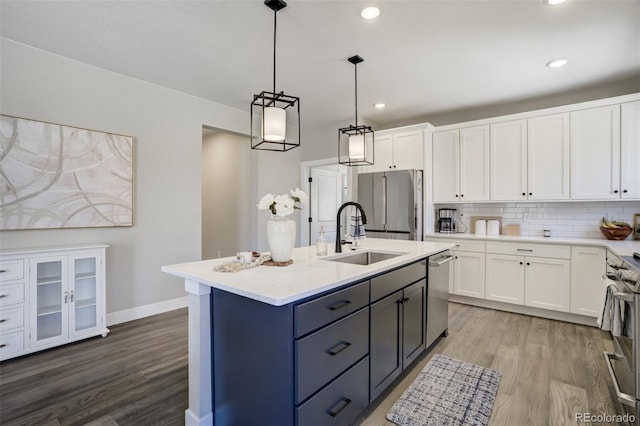 16277 Talons Bluff Ln, Monument, CO 80132 - kitchen featuring a sink, appliances with stainless steel finishes, white cabinetry, wood finished floors, and hanging light fixtures