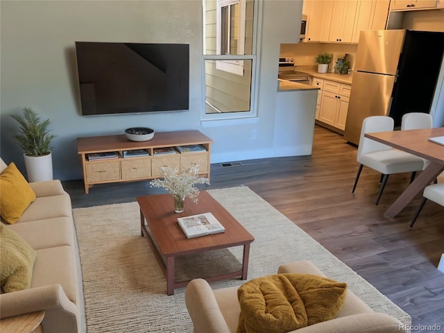 living room with visible vents, dark wood finished floors, and baseboards