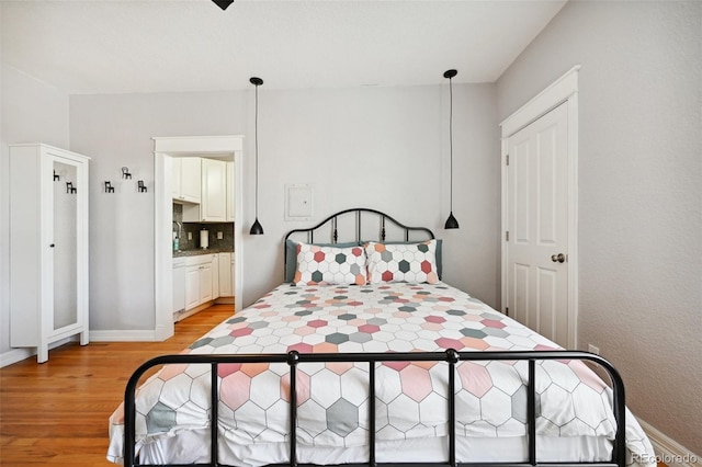 bedroom featuring light hardwood / wood-style flooring and ensuite bath