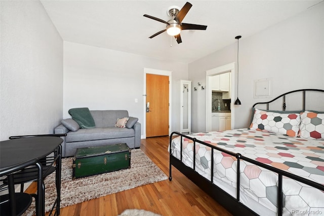 bedroom featuring ceiling fan, hardwood / wood-style floors, and sink