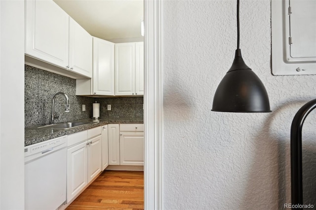 kitchen featuring dishwasher, light wood-type flooring, white cabinetry, and sink