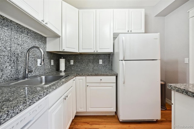 kitchen with white cabinets, white appliances, light hardwood / wood-style floors, and sink