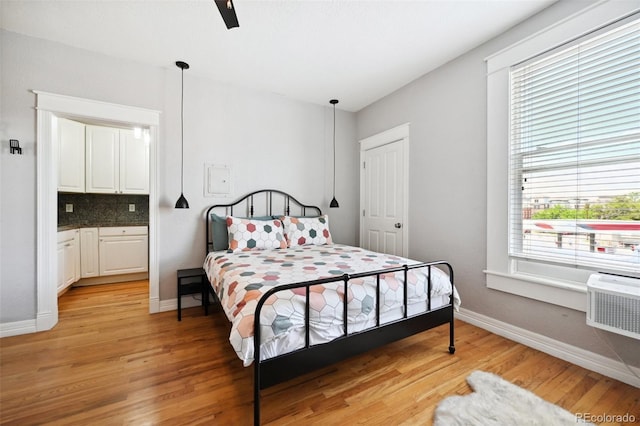 bedroom featuring ceiling fan, light hardwood / wood-style floors, and connected bathroom