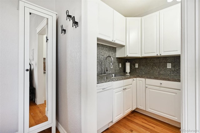 kitchen featuring dishwasher, backsplash, sink, light wood-type flooring, and white cabinetry