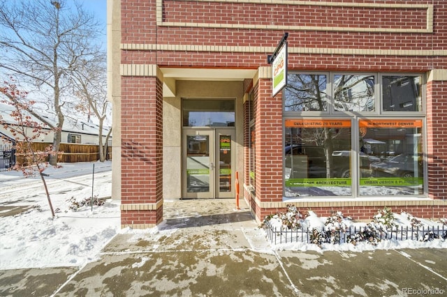 snow covered property entrance with french doors