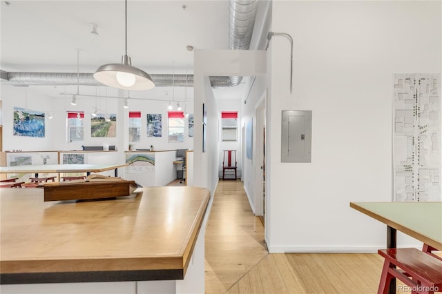 kitchen featuring decorative light fixtures, light hardwood / wood-style floors, and electric panel