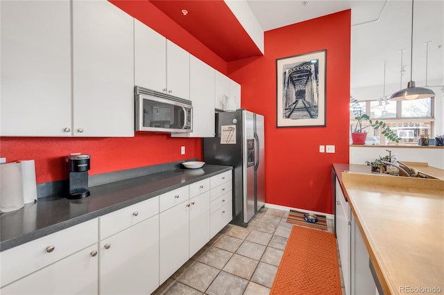 kitchen featuring white cabinetry, light tile patterned floors, and appliances with stainless steel finishes