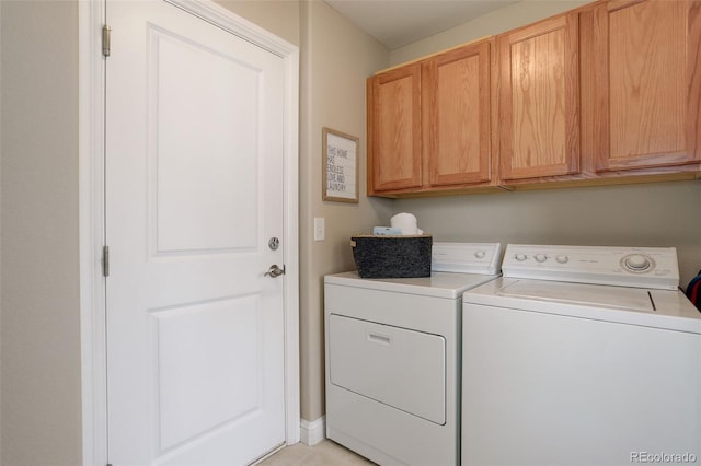 laundry area featuring light tile patterned flooring, cabinets, and washing machine and dryer