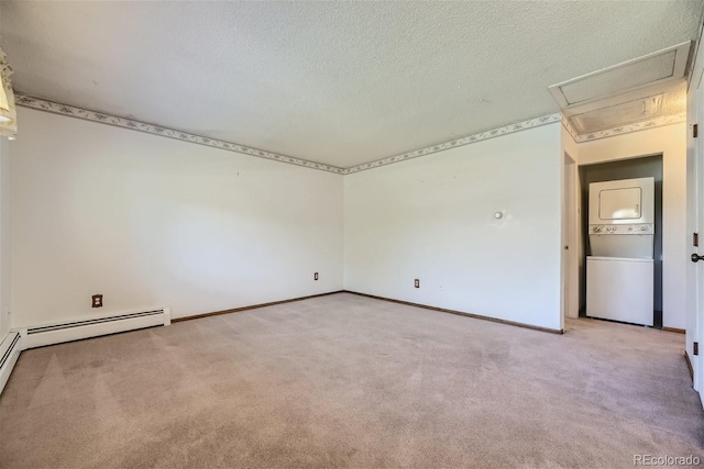 carpeted spare room with stacked washer / dryer, baseboard heating, and a textured ceiling