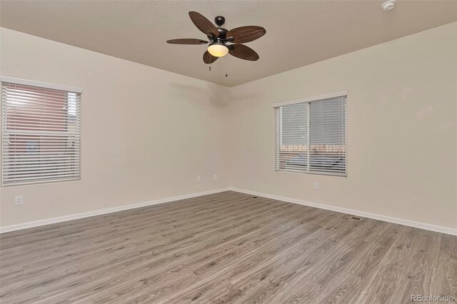 empty room featuring ceiling fan and light hardwood / wood-style floors