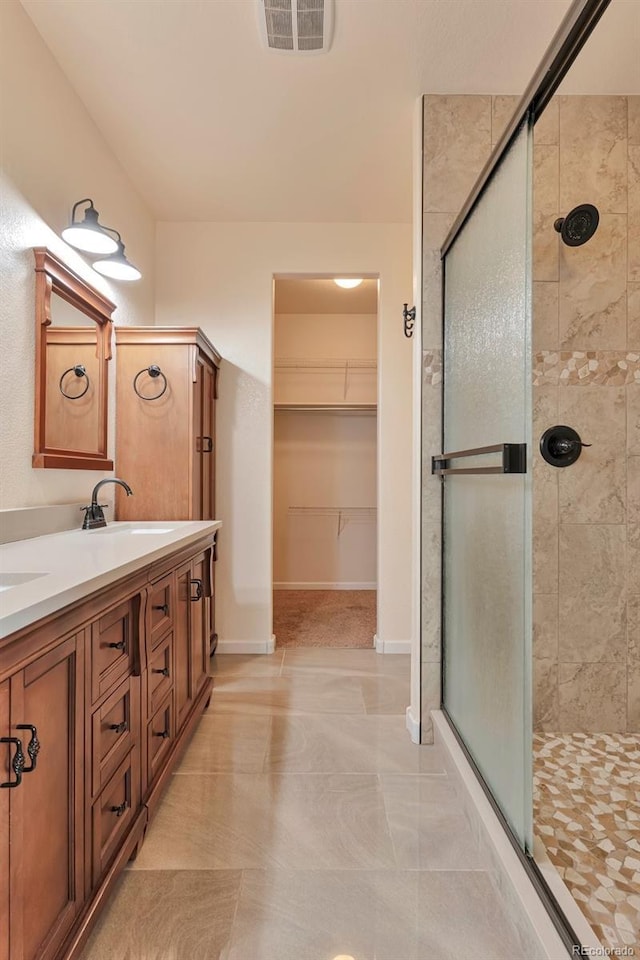 bathroom featuring vanity, tile patterned floors, and a shower with door