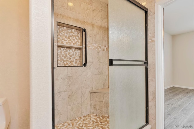 bathroom featuring toilet, wood-type flooring, and walk in shower