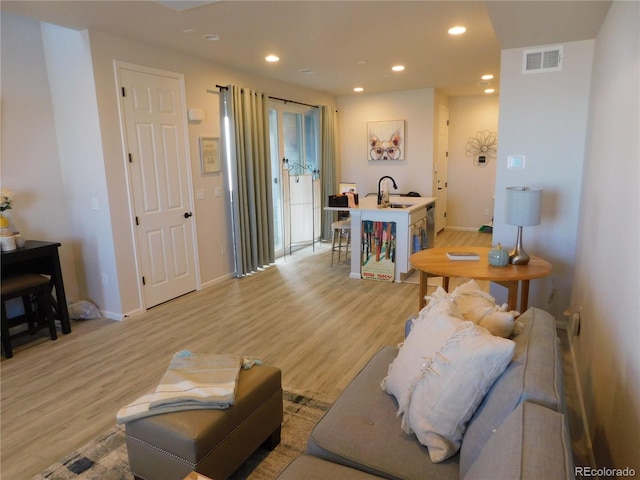 living room featuring light hardwood / wood-style floors and sink