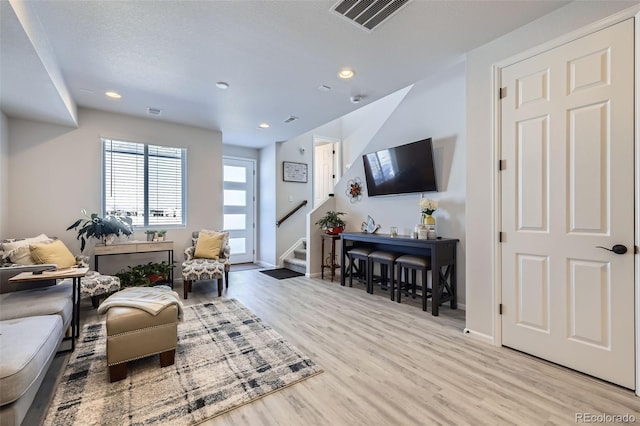 living room with light hardwood / wood-style floors and a textured ceiling