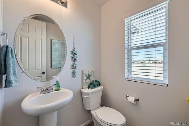 bathroom featuring sink, a healthy amount of sunlight, and toilet