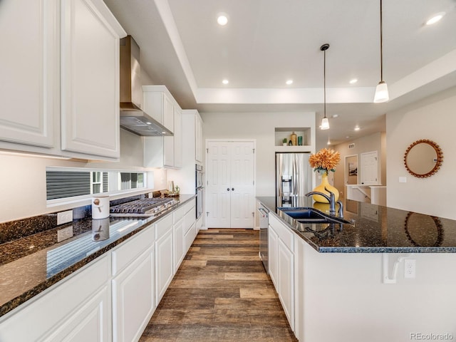 16448 E 111th Pl, Commerce City, CO 80022 - kitchen with wall chimney exhaust hood, stainless steel appliances, a sink, dark wood finished floors, and a raised ceiling