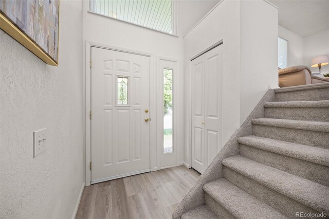 1245 Ceres Dr, Lafayette, CO 80026 - entryway with wood finished floors, stairway, baseboards, a towering ceiling, and a textured wall