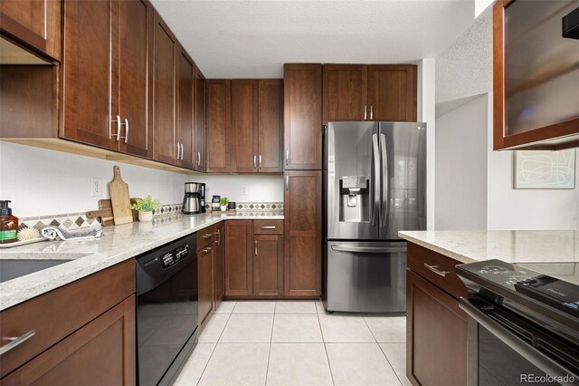 1245 Ceres Dr, Lafayette, CO 80026 - kitchen with stainless steel fridge, black dishwasher, stove, light stone counters, and light tile patterned flooring