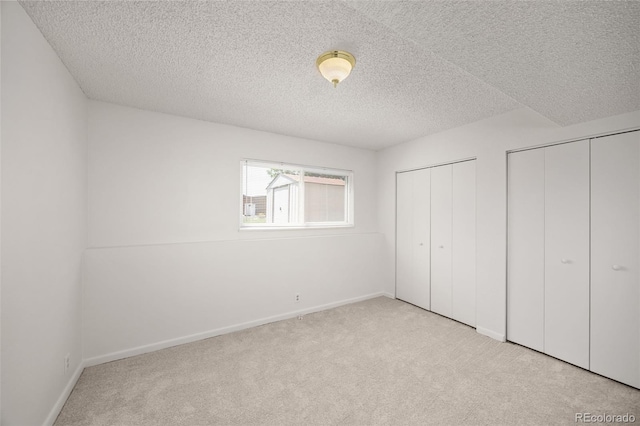 1245 Ceres Dr, Lafayette, CO 80026 - unfurnished bedroom featuring multiple closets, carpet floors, a textured ceiling, and baseboards