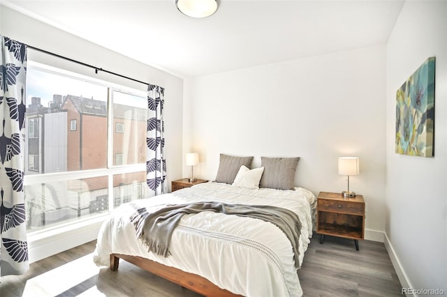 bedroom with wood finished floors and baseboards