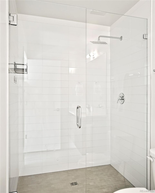 bathroom with toilet and a stall shower