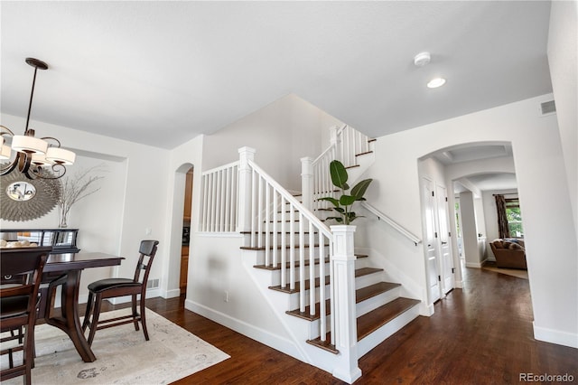 16207 Cadland Ct, Parker, CO 80134 - stairs featuring arched walkways, a chandelier, wood finished floors, and recessed lighting