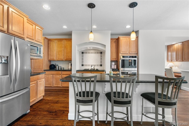 16207 Cadland Ct, Parker, CO 80134 - kitchen with stainless steel appliances, dark countertops, recessed lighting, a center island with sink, and decorative backsplash