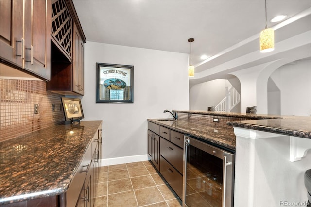 16207 Cadland Ct, Parker, CO 80134 - kitchen with wine cooler, tasteful backsplash, dark stone counters, and light tile patterned flooring