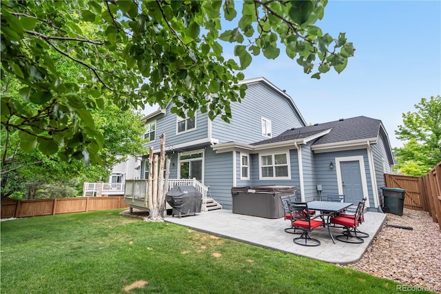 16207 Cadland Ct, Parker, CO 80134 - back of property with a hot tub, a patio, a fenced backyard, and a deck