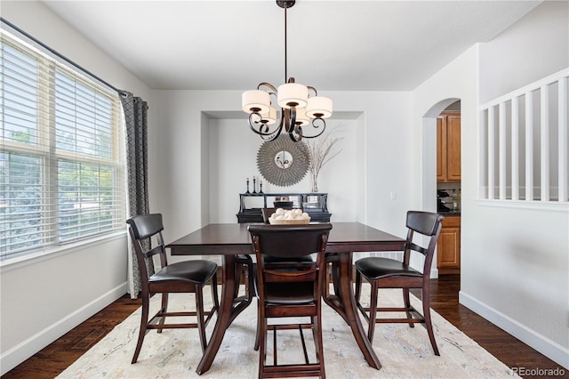 16207 Cadland Ct, Parker, CO 80134 - dining space featuring arched walkways, wood finished floors, and a chandelier