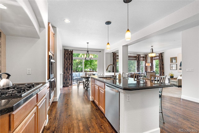 16207 Cadland Ct, Parker, CO 80134 - kitchen with dishwasher, gas cooktop, a breakfast bar, dark wood finished floors, and a textured ceiling