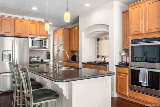 16207 Cadland Ct, Parker, CO 80134 - kitchen featuring stainless steel appliances, backsplash, dark wood-type flooring, an island with sink, and recessed lighting