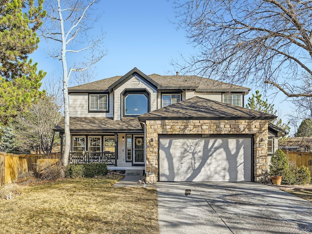 traditional-style home with covered porch, driveway, a garage, and fence