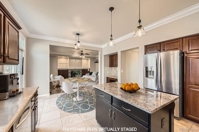 kitchen featuring pendant lighting, a center island, appliances with stainless steel finishes, and ornamental molding