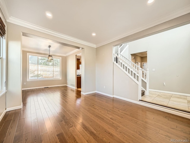 unfurnished living room with crown molding, stairs, dark wood-type flooring, and baseboards