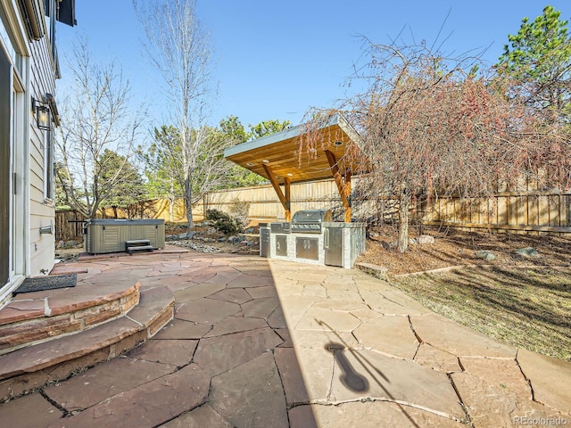 view of patio featuring area for grilling, a fenced backyard, and a hot tub